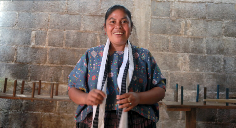 Olivia, a former participant of our program in Guatemala, shows off the scarf she made through her business.