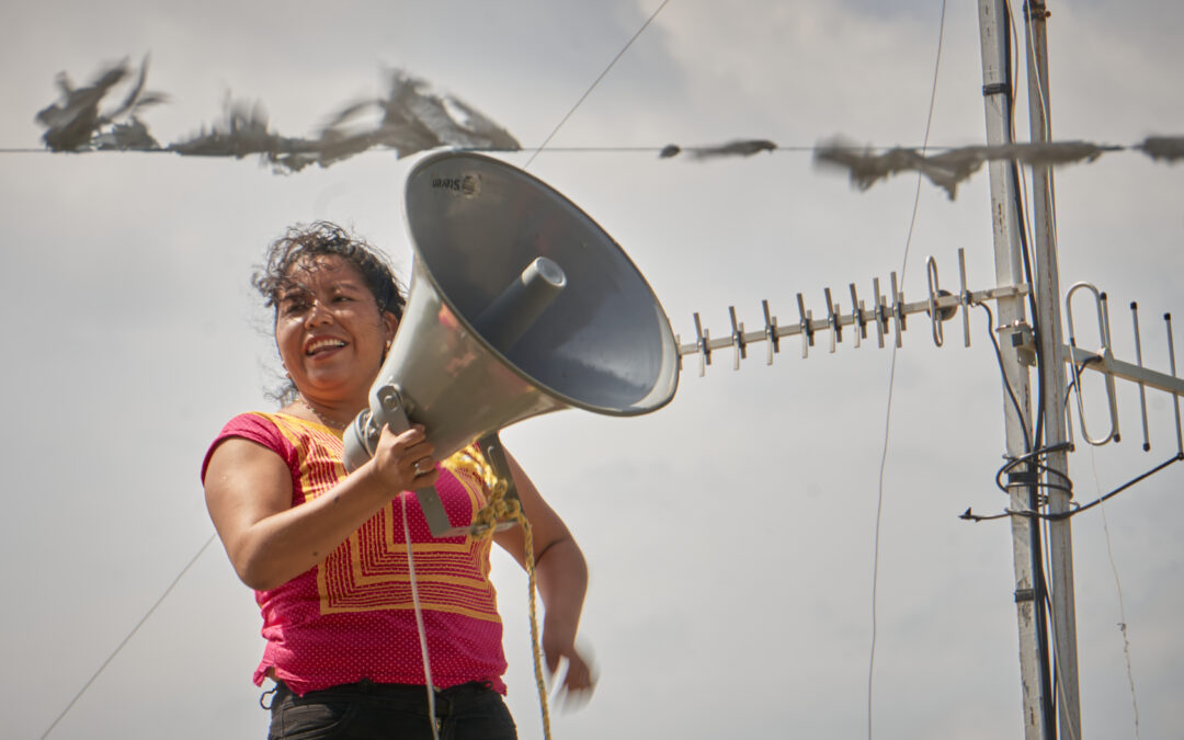 Woman standing with megaphone. Oaxaca, Mexico.